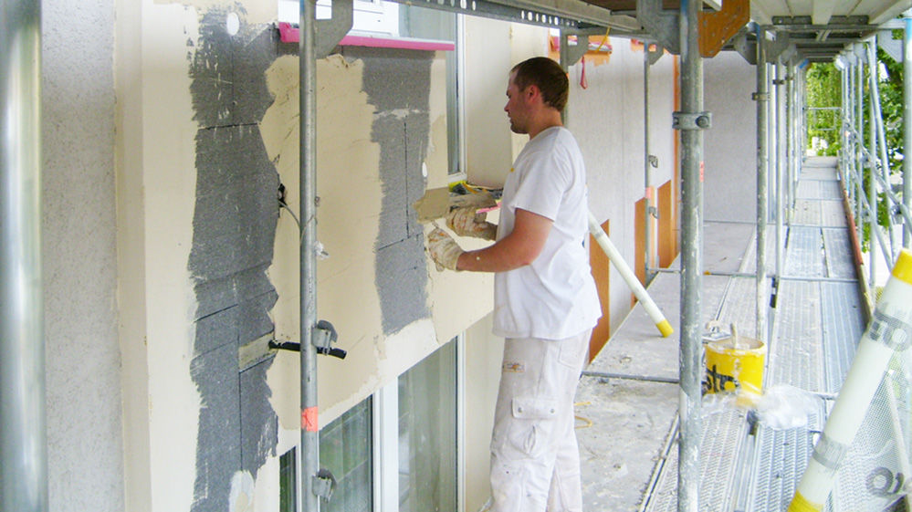 Arbeiter beim Verputzen einer Fassadendämmplatte